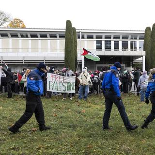 Des manifestants contre la venue d'Emmanuel Macron rassemblés sur le campus de l'université de Lausanne. [Keystone - Cyril Zingaro]