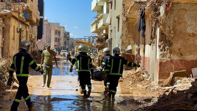 Des membres des équipes de sauvetage de l'armée égyptienne portent un corps dans les rues de Derna. [Reuters - Ahmed Elumami]