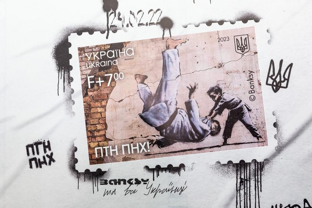 La poste ukrainienne a émis un timbre reproduisant une oeuvre de Banksy, dans laquelle un jeune judoka met au tapis un homme adulte. [AFP - Dominika Zarzycka / NurPhoto]