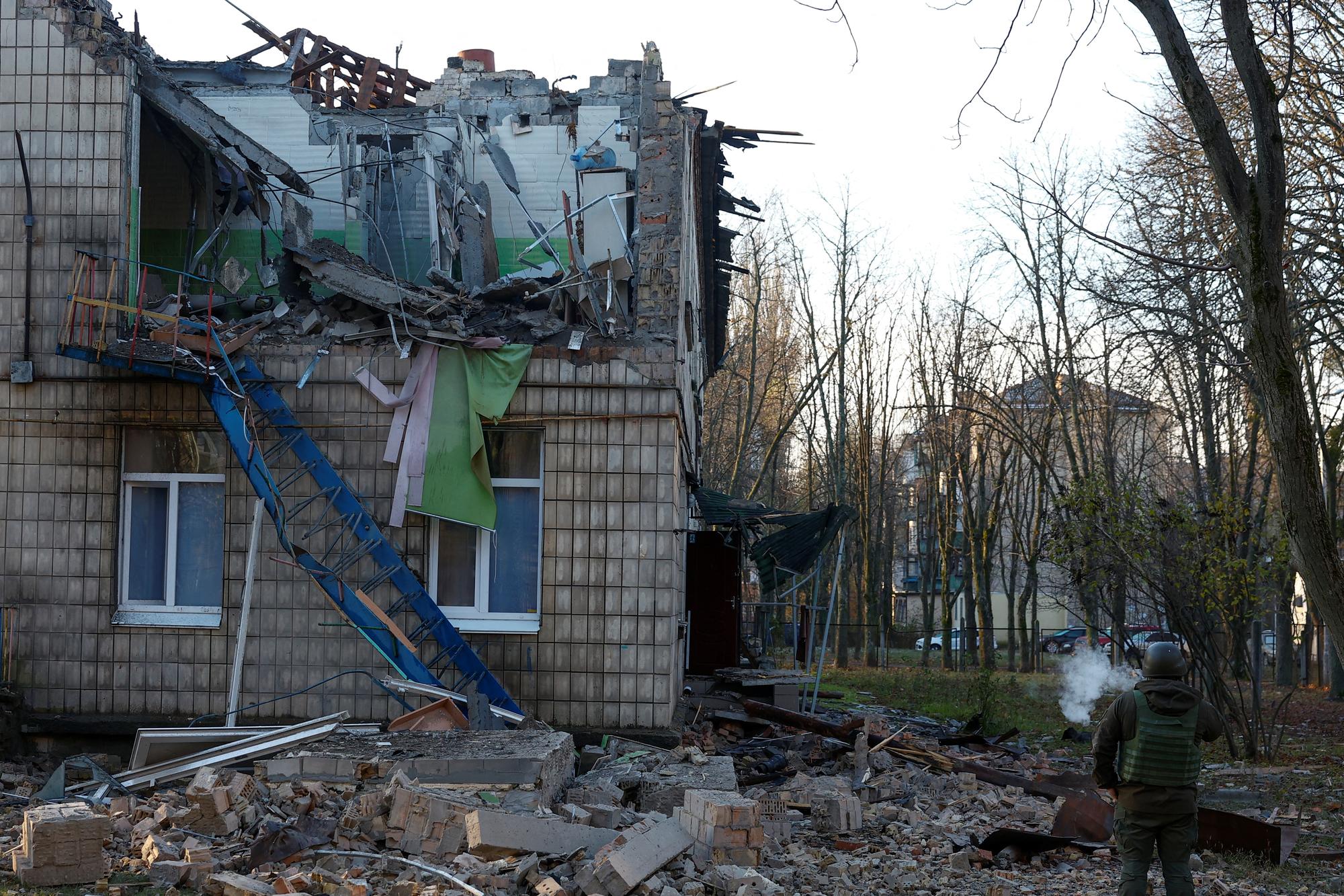 Des policiers inspectent l'enceinte d'un jardin d'enfants endommagé par des frappes de drones russes contre Kiev, le 25 novembre 2023. [REUTERS - VALENTYN OGIRENKO]