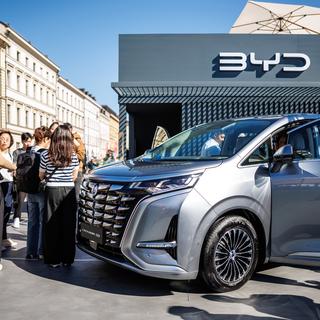 Les visiteurs du stand regardent une Denza D9 sur le stand du constructeur chinois BYD, dans l'espace ouvert du salon automobile IAA 2023 de la ville. [Keystone/DPA - Matthias Balk]