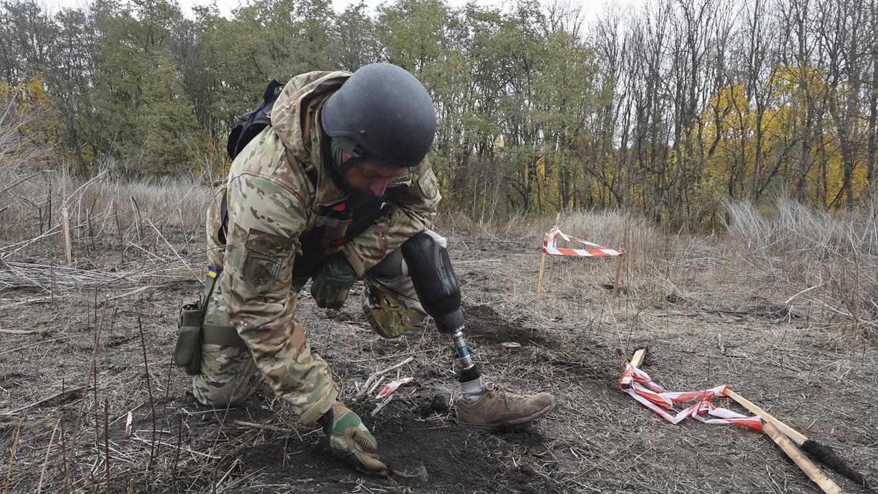 Un soldat en pleine opération de déminage dans la région de Kharkiv, en Ukraine. [Keystone - EPA/Sergey Kozlov]