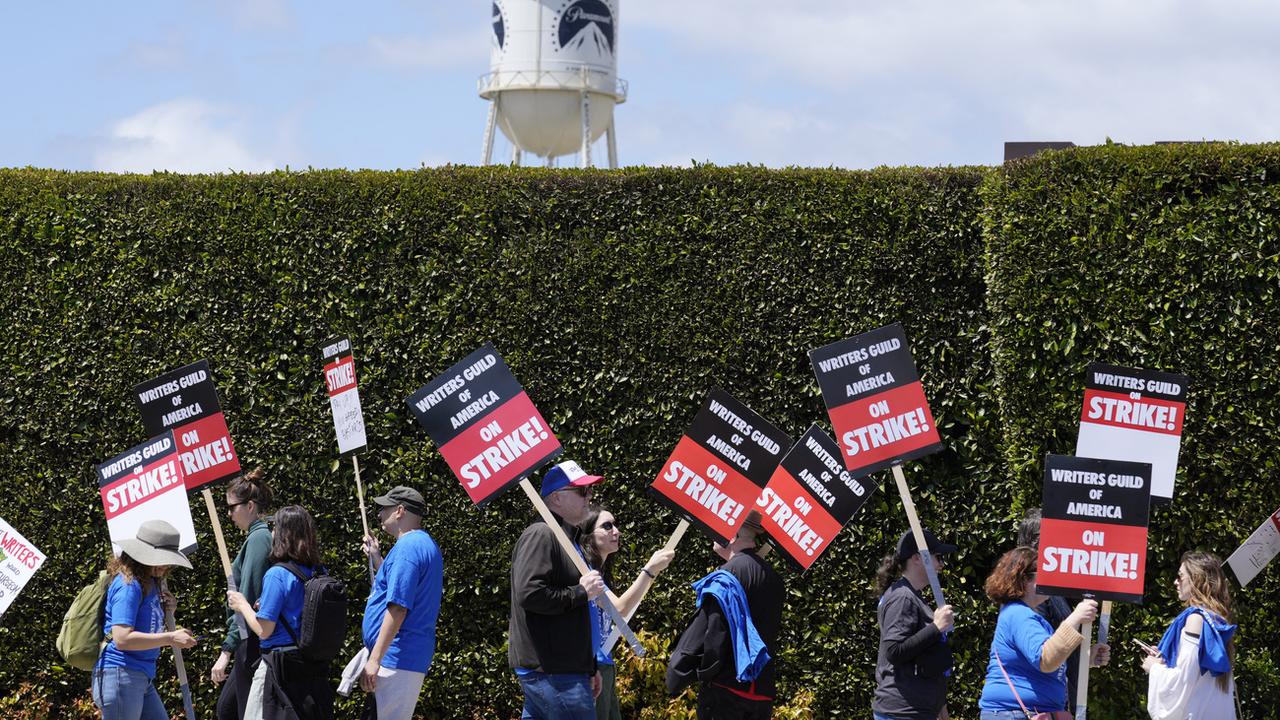 Des grévistes défilent devant les studios Paramount Pictures pour demander une revalorisation salariale et contractuelle des scénaristes à Hollywood. [Keystone/AP Photo - Chris Pizzello]