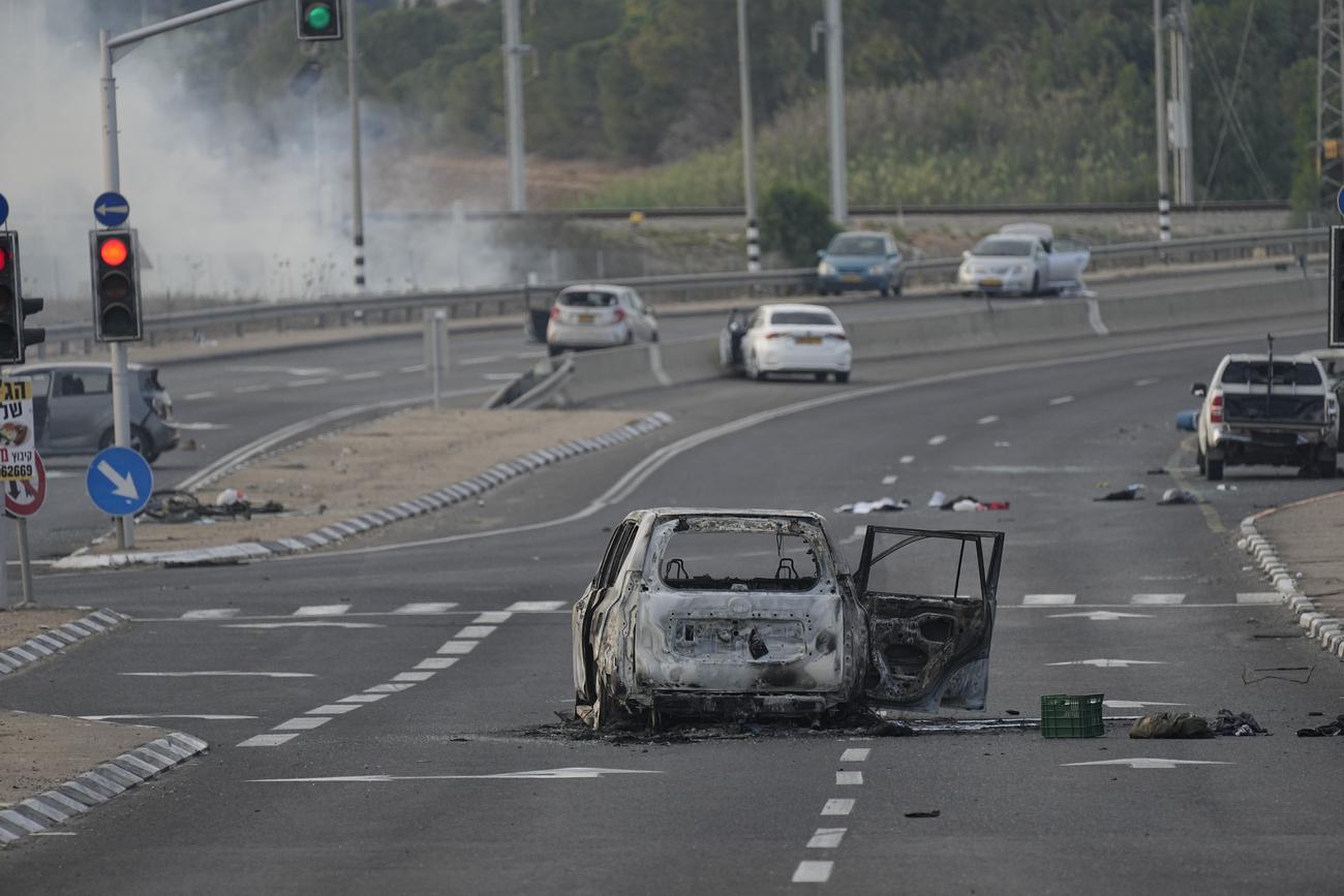 Une voiture détruite lors d'une attaque par des militants palestiniens est vue à Sderot, Israël, le samedi 7 octobre 2023. [Keystone - AP Photo/Ohad Zwigenberg]
