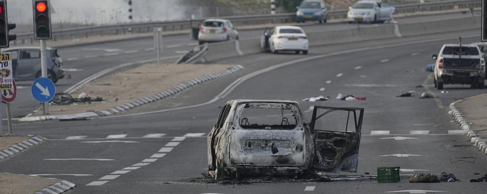 Une voiture détruite lors d'une attaque par des militants palestiniens est vue à Sderot, Israël, le samedi 7 octobre 2023. [Keystone - AP Photo/Ohad Zwigenberg]