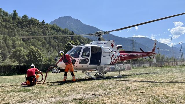 Un hélicoptère d'Air Glaciers se prépare à aller lutter contre les incendies en Haut-Valais. [RTS - Mathieu Henderson]