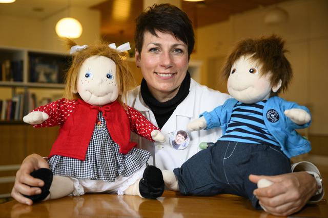 La professeure Patrizia D'Amelio, médecin cheffe au Service de gériatrie du Centre hospitalier universitaire vaudois (CHUV), pose avec deux poupées thérapeutiques destinées au traitement des démences chez les personnes âgées, à Lausanne, le 12 janvier 2023. [KEYSTONE - Laurent Gillieron]