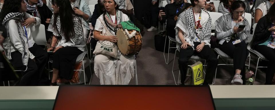 Des militants pro-palestiniens portant des keffiehs à une session sur la sécurité alimentaire organisée par une organisation israélienne, lors du sommet climatique de l'ONU COP28, le 9 décembre 2023 à Dubaï. [Keystone - Peter Dejong]