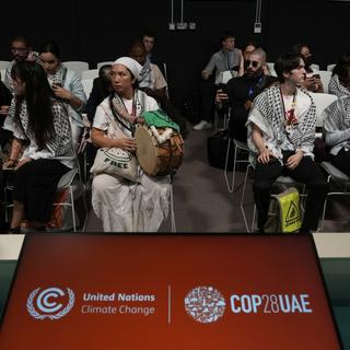 Des militants pro-palestiniens portant des keffiehs à une session sur la sécurité alimentaire organisée par une organisation israélienne, lors du sommet climatique de l'ONU COP28, le 9 décembre 2023 à Dubaï. [Keystone - Peter Dejong]
