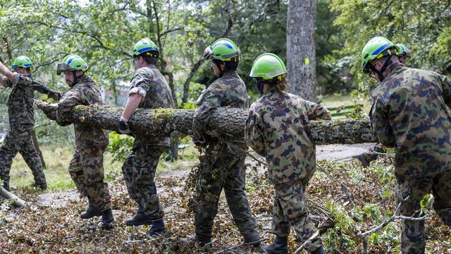 Des militaires de l'armée suisse effectuent des travaux de bûcheronnage près d'une école de La Chaux-de-Fonds. [keystone - Martial Trezzini]