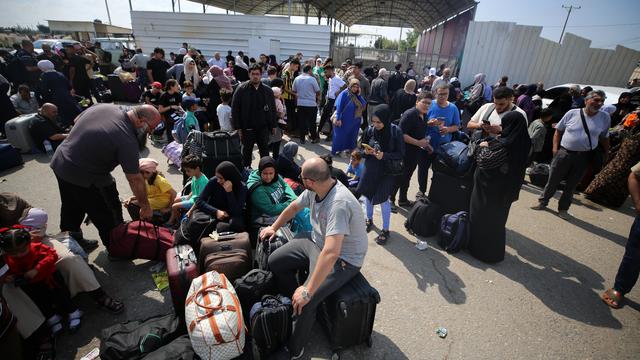 Des centaines de personnes, parfois binationales, attendent de pouvoir quitter la bande de Gaza pour l'Egypte au poste-frontière de Rafah. [AFP - Majdi Fathi/NurPhoto]