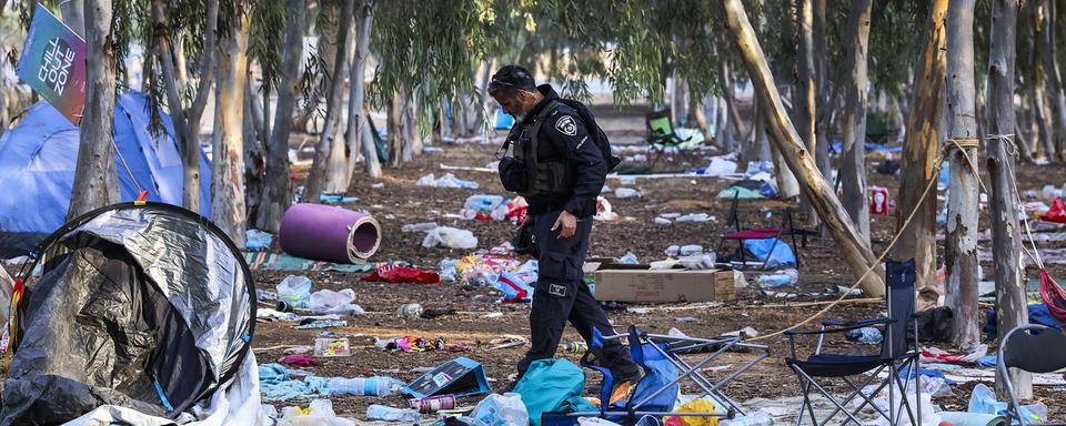 Un policier israélien présent sur le site du festival Super Nova, pris pour cible par le Hamas. [Keystone - Manuel de Almeida]