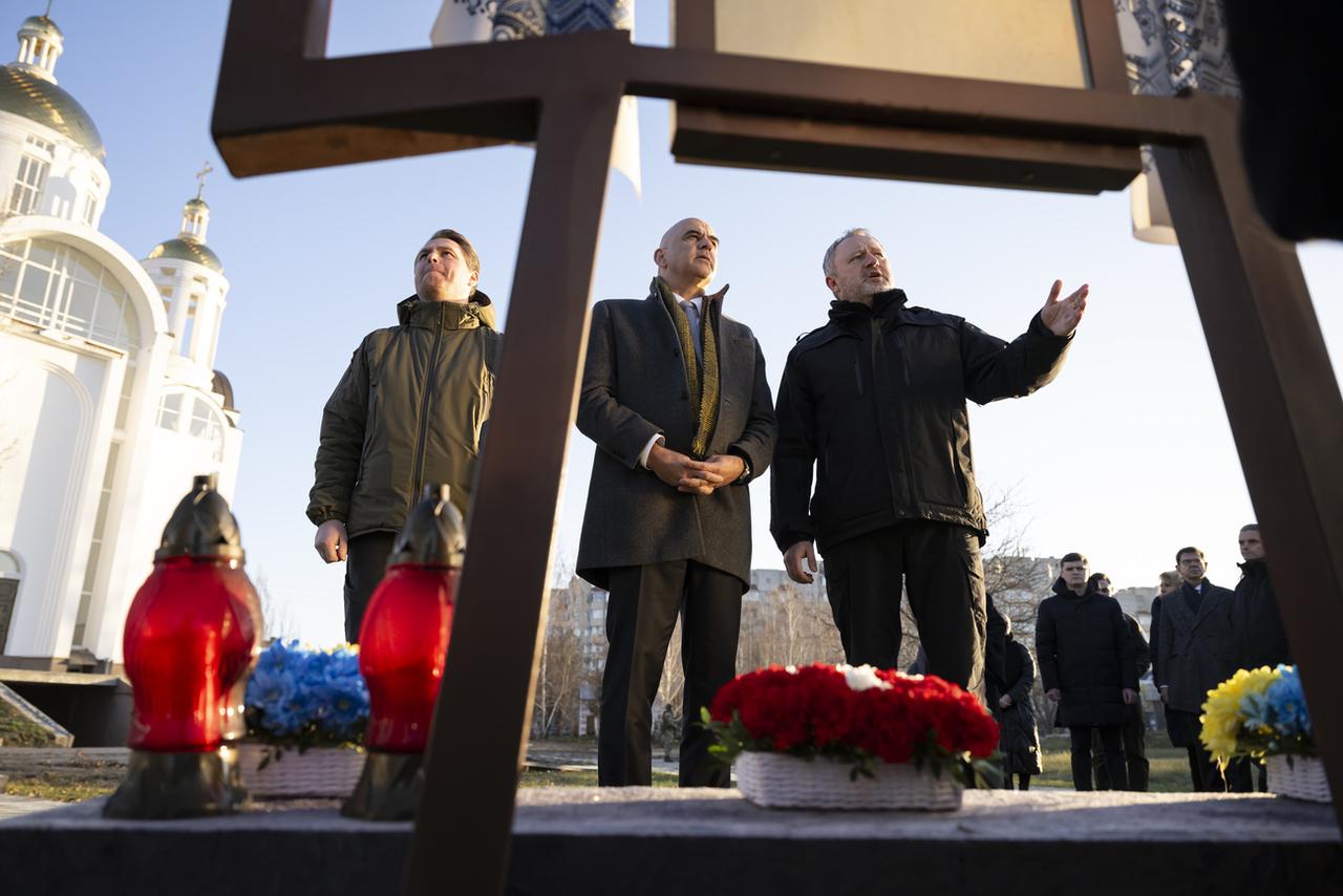 Le maire de Bucha Ruslan Kravchenko (à gauche), le procureur général Andriy Kostin (à droite) et le président de la Confédération Alain Berset, lors d'une cérémonie de commémoration, à l'église Saint-André à Bucha en Ukraine, le 25 novembre 2023. [KEYSTONE - ANTHONY ANEX]