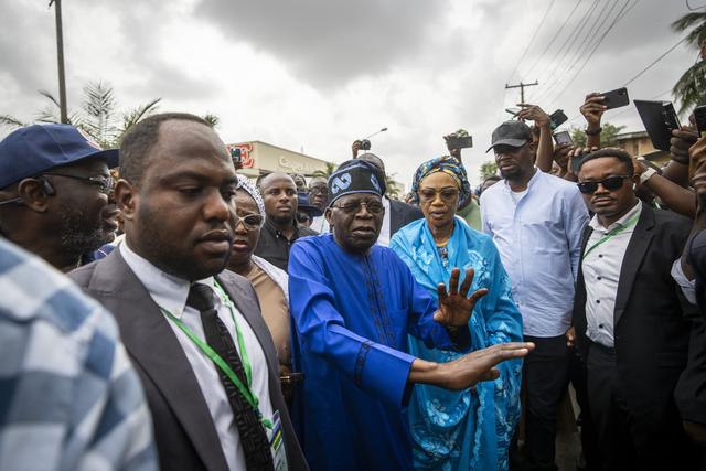 Le candidat du parti All Progressives Congress, Bola Tinubu (au centre) arrive au bureau de vote à Lagos, le 25 février. [Keystone - AP Photo/Ben Curtis]