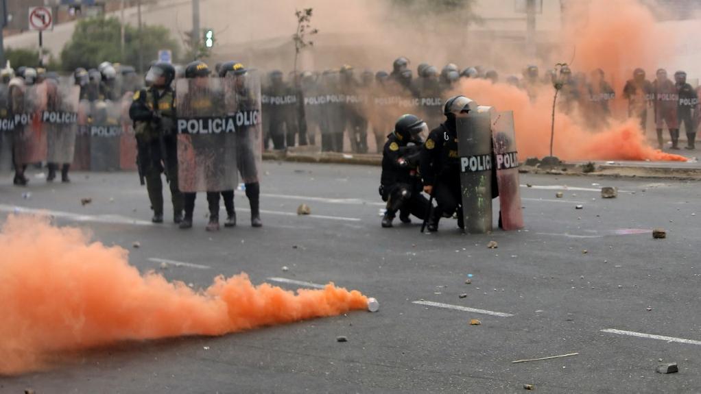 A coups de pied, des centaines de manifestants, encagoulés et munis de boucliers, ont affronté la police près du Parlement péruvien, samedi à Lima. [afp - Lucas AGUAYO]