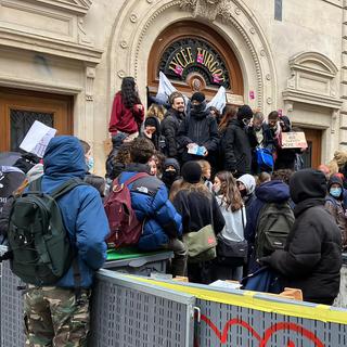 Des étudiantes et étudiants français bloquent un lycée à Paris en marge de la manifestation contre la réforme des retraites du gouvernement Macron. [Keystone/AP Photo - Nicolas Garriga]