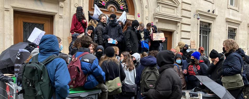 Des étudiantes et étudiants français bloquent un lycée à Paris en marge de la manifestation contre la réforme des retraites du gouvernement Macron. [Keystone/AP Photo - Nicolas Garriga]