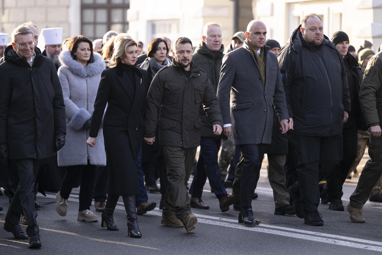 Le président ukrainien Volodymyr Zelensky et son épouse Olena Zelenska marchent à côté d'Alain Berset, président de la Confédération, lors de la cérémonie de commémoration des victimes de l'Holodomor (1932-1933) en Ukraine, à Kiev, le 25 novembre 2023. [KEYSTONE - ANTHONY ANEX]