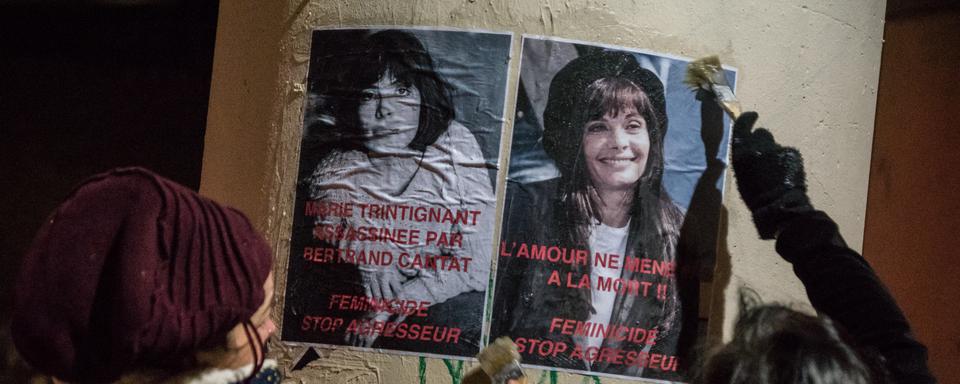 Des féministes collent des affiches représentant Marie Trintignant la veille du concert de Bertrand Cantat au Transbordeur de Lyon, en France, le 20 mars 2018. [NURPHOTO VIA AFP - NICOLAS LIPONNE]