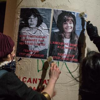 Des féministes collent des affiches représentant Marie Trintignant la veille du concert de Bertrand Cantat au Transbordeur de Lyon, en France, le 20 mars 2018. [NURPHOTO VIA AFP - NICOLAS LIPONNE]