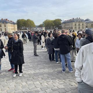 Mardi 17 octobre: les visiteurs et visiteuses du Château de Versailles évacués après une alerte à la bombe. [Keystone - AP Photo/Pat Eaton-Robb]