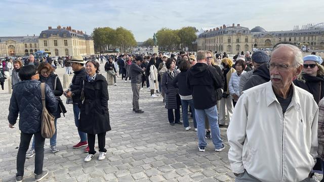 Mardi 17 octobre: les visiteurs et visiteuses du Château de Versailles évacués après une alerte à la bombe. [Keystone - AP Photo/Pat Eaton-Robb]