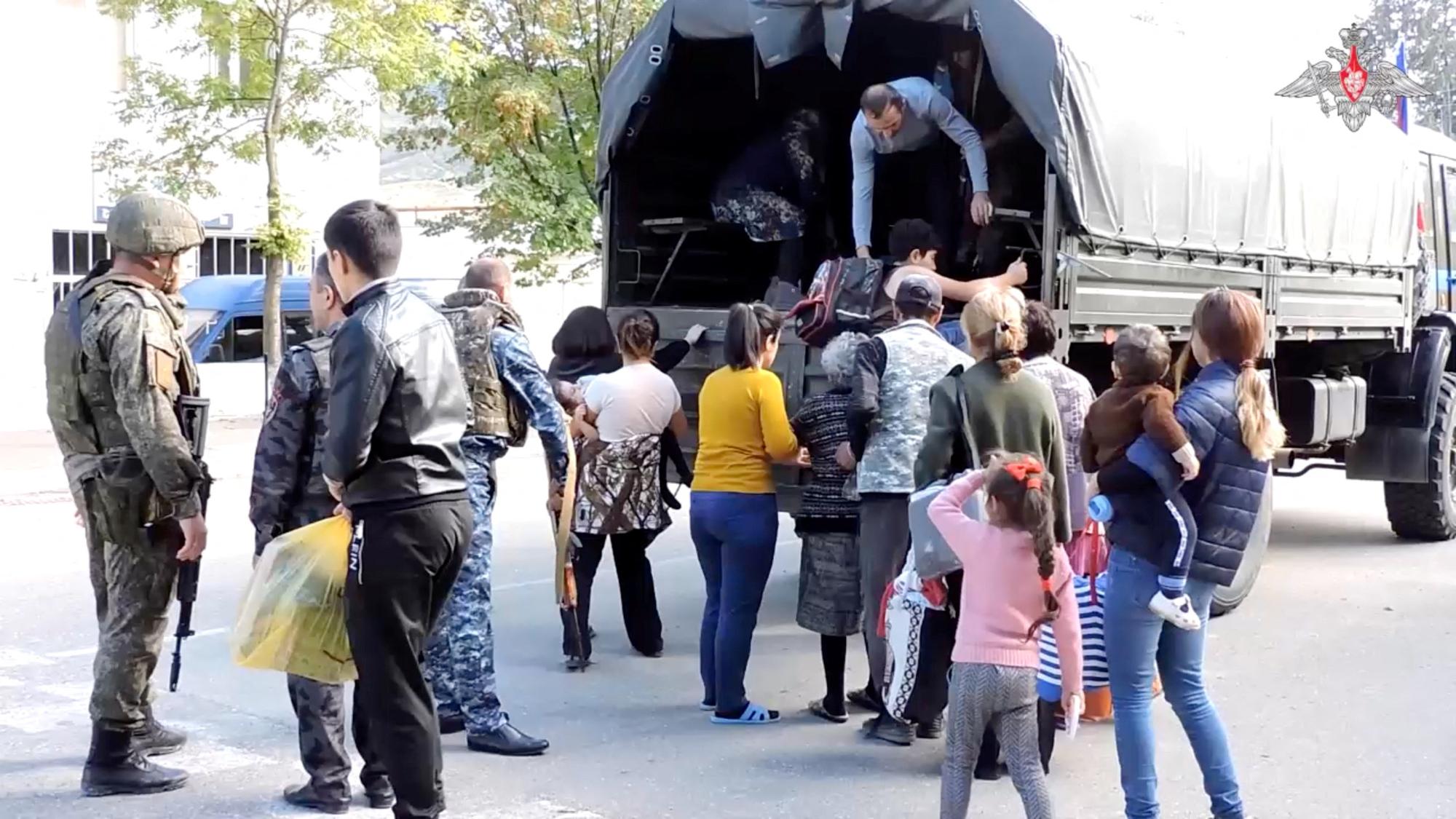Des soldats russes évacuent les civils de la ville d'Askeran, dans le Haut Karabakh, le mercredi 20 septembre 2023. [keystone - Ministère russe de la Défense]