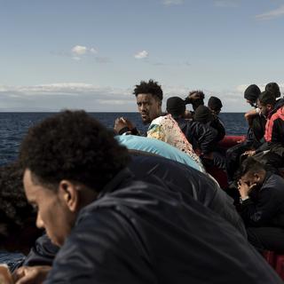 Des hommes migrants sont rassemblés sur le pont du bâteau de sauvetage de l'Ocean Viking en Mer Méditerranée. [Keystone/AP Photo - Vincenzo Circosta]