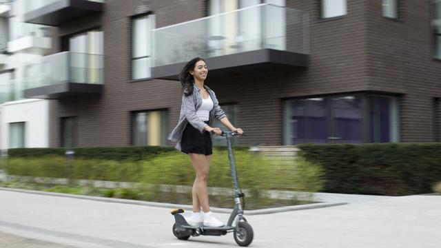 Une jeune femme qui fait de la trottinette électrique. [AFP - Martin Barraud / CAIA IMAGE / SCIENC / NEW / Science Photo Library]