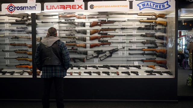 Un homme regarde une exposition d'armes à feu à vendre dans un magasin spécialisé . [Hannah McKay]