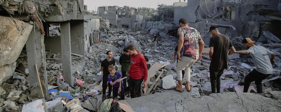 Le 5 novembre 2023, des civils palestiniens et des équipes de secours fouillent les ruines d'une structure effondrée à Al-Maghazi, au centre de la bande de Gaza. [AFP]