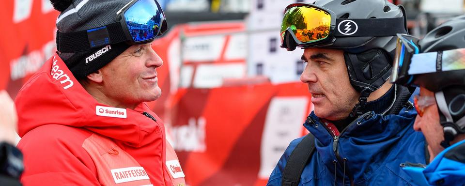 Le président de la Fédération suisse de ski, Urs Lehmann (à gauche), s'entretient avec le président suisse Alain Berset avant la descente de la Coupe du monde masculine de ski alpin FIS à Wengen, en Suisse, le 14 janvier 2023. [AFP - Fabrice Coffrini]