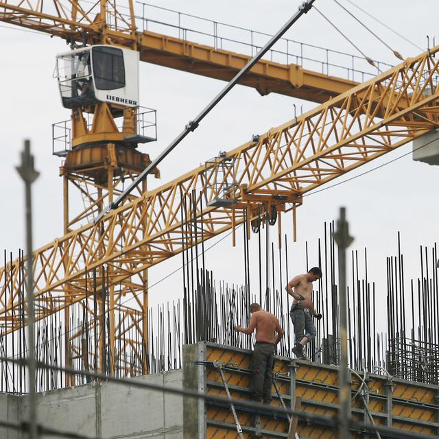 Un chantier de construction avec deux ouvriers à Berlin, Allemagne (image d'illustration). [Keystone/AP Photo - Maya Hitij]