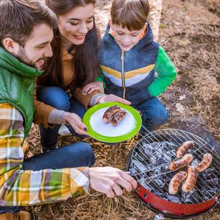 Un couple et leur enfant font un barbecue dans la forêt. [Depositphotos - RomanPashkovsky]