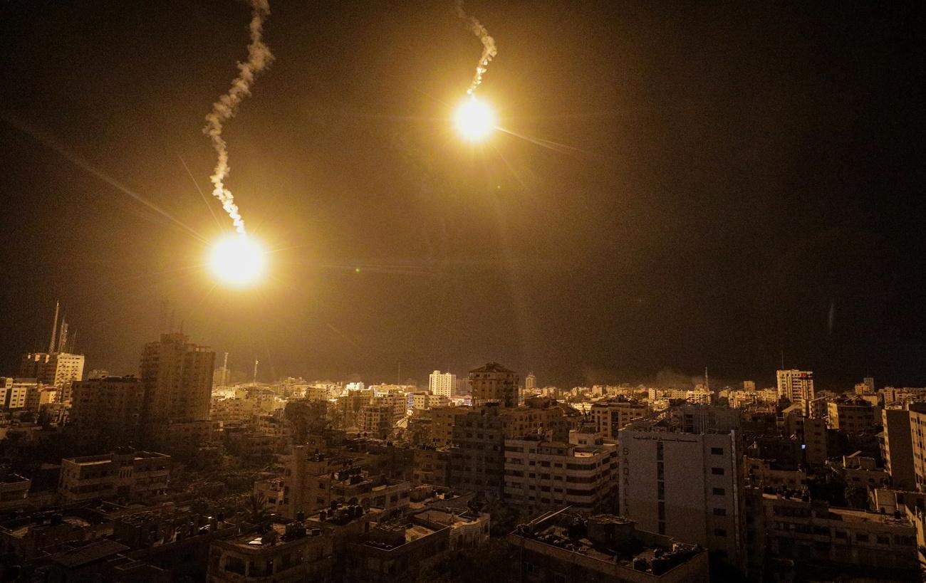 Des tirs israéliens au-dessus de la bande de Gaza, dans la nuit du 9 au 10 novembre 2023. [EPA/Keystone - Mohammed Saber]