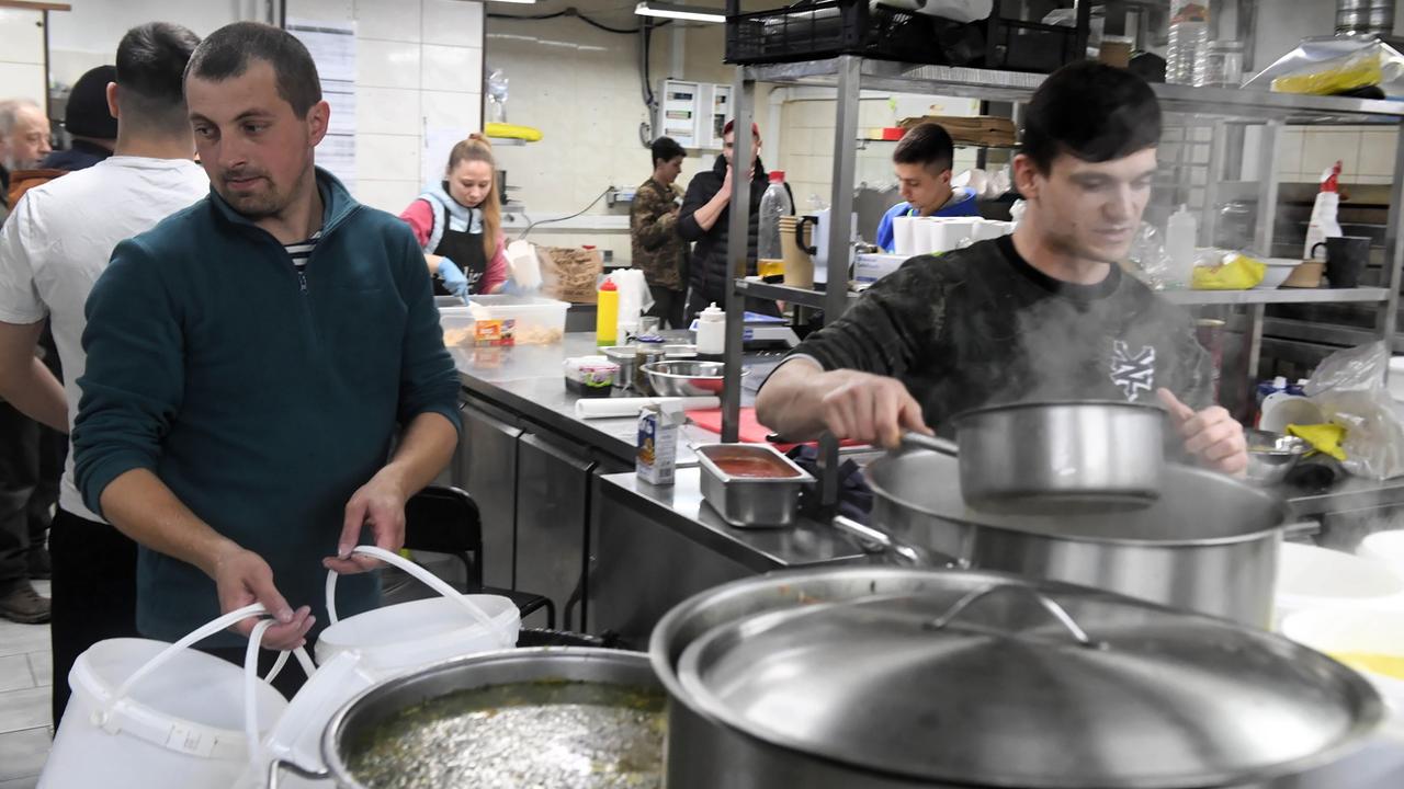 Des personnes préparent un repas pour les soldats ukrainiens engagés au front, dans la cuisine d'un restaurant de Kharkiv, le 22 mars 2022. [EPA/Keystsone - Andrzej Lange]