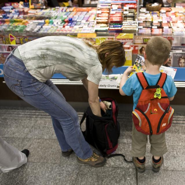Une femme et un petit garçon dans un kiosk à journaux en Suisse (image d'illustration). [KEYSTONE - Martin Ruetschi]