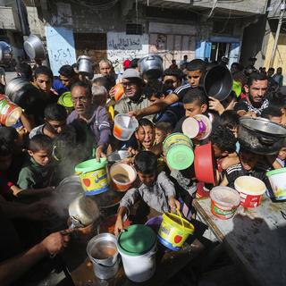 Des Palestiniens s'entassent dans l'attente d'une distribution de nourriture à Rafah, dans le sud de la bande de Gaza, mercredi 8 novembre 2023. [Keystone - AP Photo/Hatem Ali]