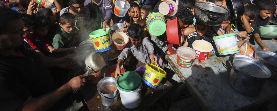 Des Palestiniens s'entassent dans l'attente d'une distribution de nourriture à Rafah, dans le sud de la bande de Gaza, mercredi 8 novembre 2023. [Keystone - AP Photo/Hatem Ali]