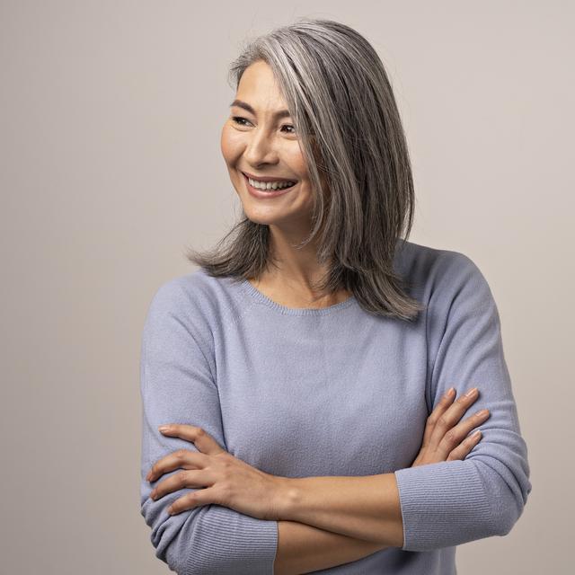 Souriant asiatique senior femme avec les bras croisés. [Depositphotos - ©Svyatoslavlipik]