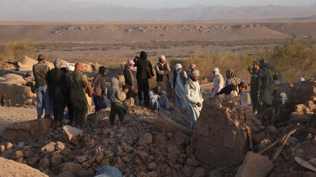 Des personnes cherchent des survivants dans des maisons effondrées dans la province d'Herat. [AFP - Mashal/Xinhua]