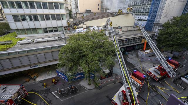 Des pompiers du SIS interviennent sur un incendie de la toiture du cinéma Le Plaza, à Genève. [Keystone - Martial Trezzini]