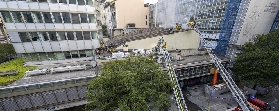 Des pompiers du SIS interviennent sur un incendie de la toiture du cinéma Le Plaza, à Genève. [Keystone - Martial Trezzini]