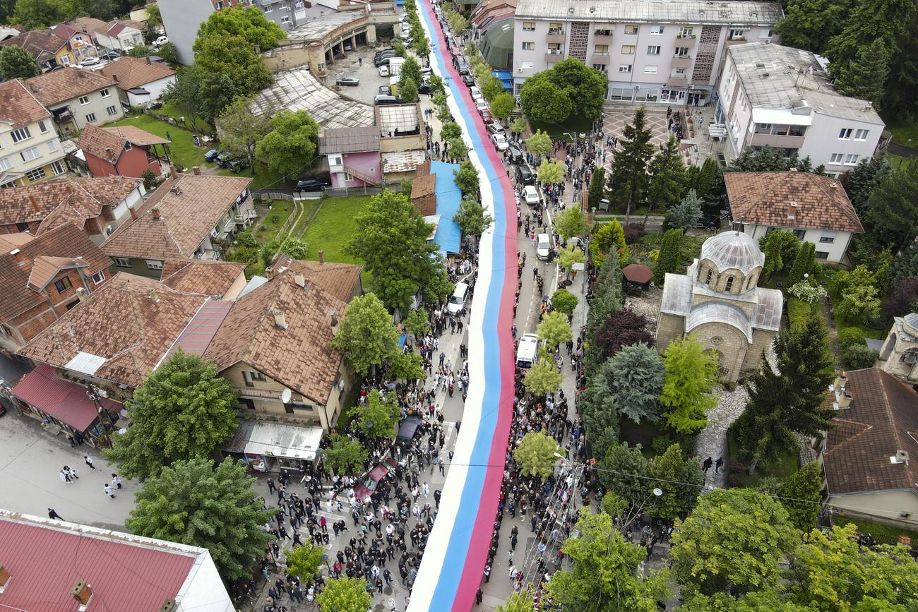 Les manifestants ont déployé un gigantesque drapeau serbe de plus de 200 mètres de long entre le centre-ville et les abords de la mairie de Zvecan. [Keystone - Bojan Slavkovic - AP Photo]
