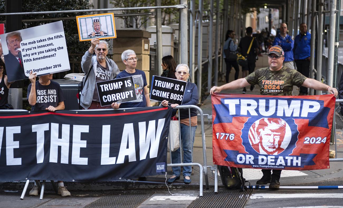 Une poignée d'opposants et de partisans attendaient Donald Trump devant les bureaux de la procureure générale de l'Etat de New York, le 13 avril 2023. [KEYSTONE - CRAIG RUTTLE]
