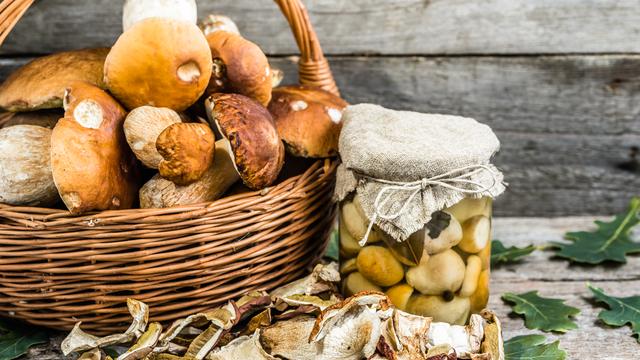 Conserves automnales de champignons, champignons secs et bolets marinés dans un bocal sur table en bois. [Depositphotos - ©Alicjane]