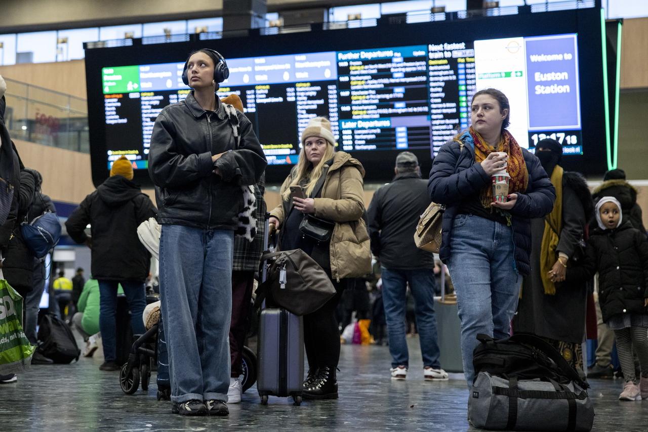 Des passagers devant le panneaux des correspondance à la garde de Euston, à Londres, les 3 janvier 2023. [EPA/Keystone - Tolga Akemn]