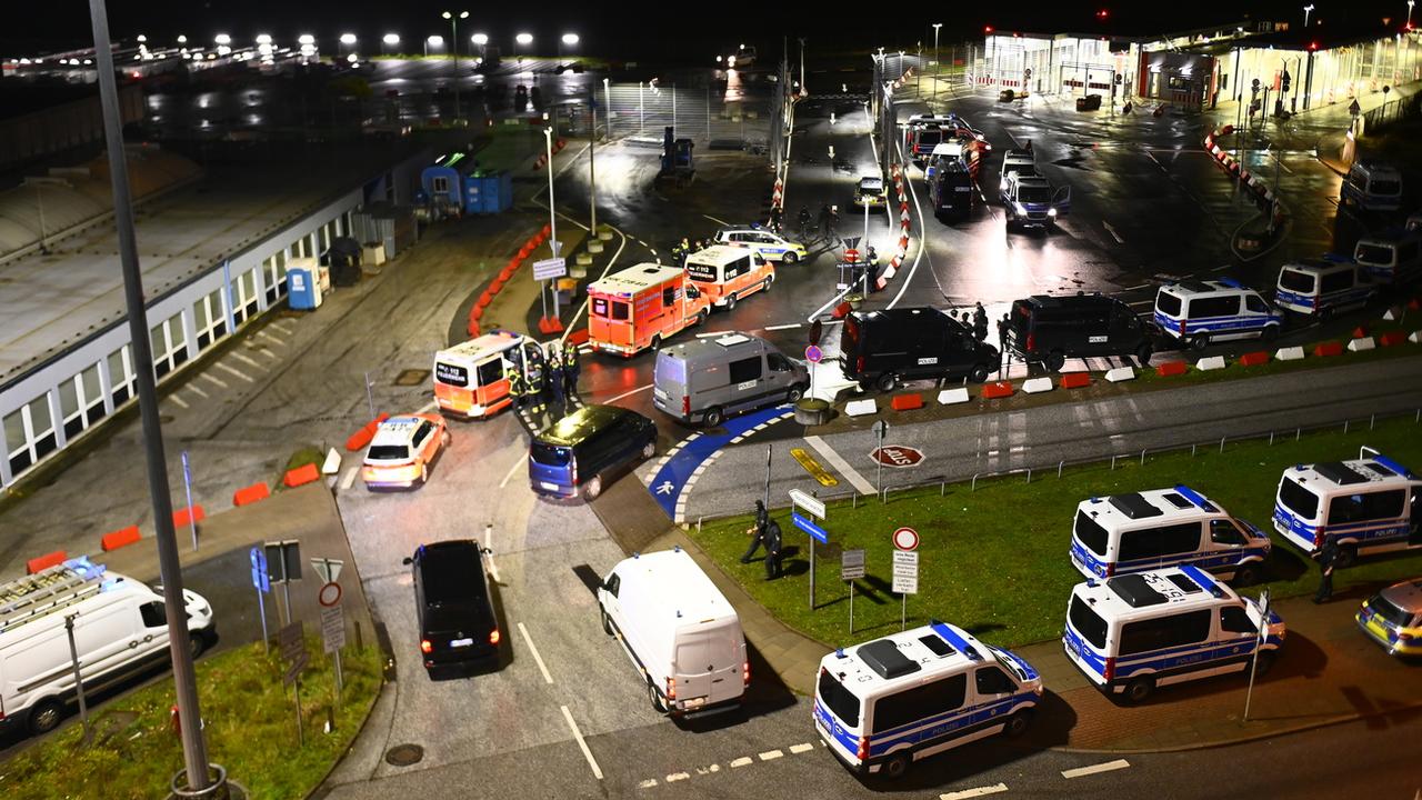 Des véhicules de police et des ambulances stationnés sur le tarmac de l'aéroport de Hambourg, fermé après l'intrusion d'une voiture dans l'enceinte. [Keystone - Jonas Walzberg / DPA]