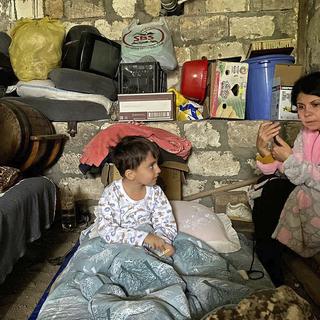 Des femmes et des enfants s'abritent dans un refuge lors d'un bombardement à Stepanakert, dans le Haut Karabakh. [AP/Keystone - Siranush Sargsyan]