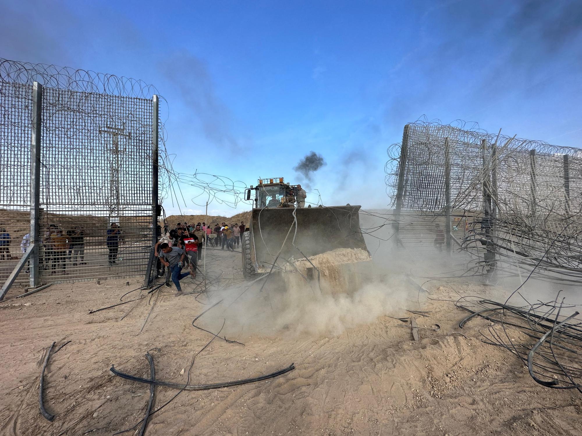 Des Palestiniens pénètrent du côté israélien de la barrière frontalière entre Israël et Gaza après que des hommes armés se soient infiltrés dans des zones du sud d'Israël, le 7 octobre 2023. [Reuters - Mohammed Fayq Abu Mostafa]